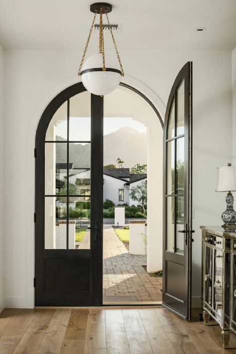 The matte black finish of the grand Aluminum Clad, arched front door makes quite a statement. The window panels on the door allow the warm, natural light to flow through. @Hoppe Verona Escutcheon door lever Doors, Exterior, Arched Entry Doors, Front Entry Doors, Entry Doors, Arched Front Door, Door Entry, Custom Front Entry Doors, Arched Doors