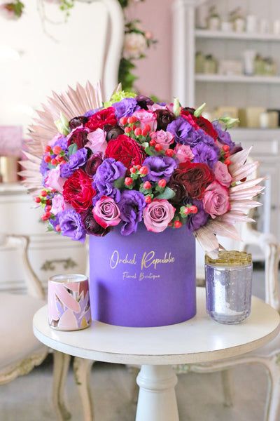 Let these bold and beautiful florals take your breath away. This hatbox flower arrangement purple lisianthus, mauve pink roses, red garden roses, burgundy ranunculus, green hydrangeas, and hypericum berries with dried fan-shaped leaves as their backdrop. It is presented in a chic purple hatbox with gold logo, which doubles as a keepsake once the blooms have faded. Pink Roses, Floral, Floral Arrangements, Flowers Bouquet Gift, Luxury Flower Bouquets, Flowers Bouquet, Flower Decorations, Beautiful Bouquet Of Flowers, Luxury Flower Arrangement