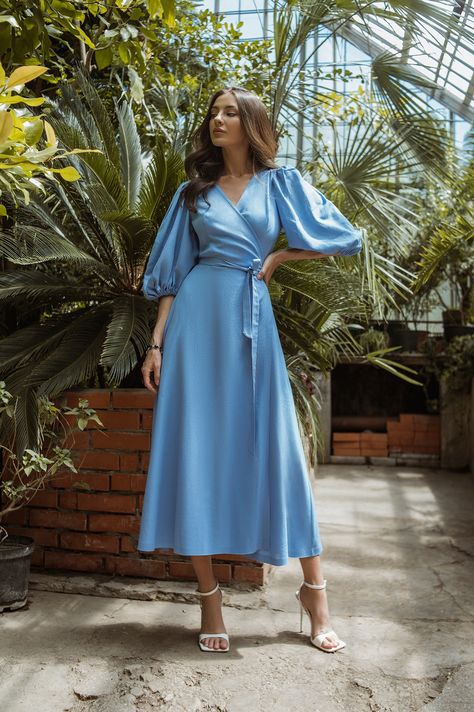Embrace the beauty of summer with our Sky-Blue Puff-Sleeve Wrap Midi Dress. The sky-blue color radiates freshness and vibrancy, while the wrap design highlights your waist and creates a graceful silhouette. The playful puff sleeves and flowy skirt add a touch of whimsy, making this dress a delightful choice for outdoor gatherings and picnics. #dress #dresses #mididress #wrapdress #summerdress #weddingdress #eveningdress #dresslover #skyblue #womenwear #fashion Blue Midi Dress, Blue Flowy Dress, Flowy Midi Dress, Blue Spring Dresses, Midi Dress, Light Blue Midi Dress, Blue Summer Dresses, Blue Long Sleeve Dress, Light Blue Summer Dress
