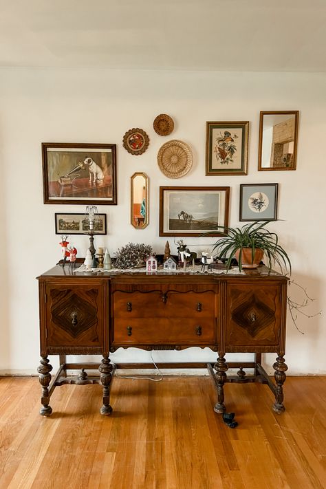Antique buffet with random wall decor hanging above it.
