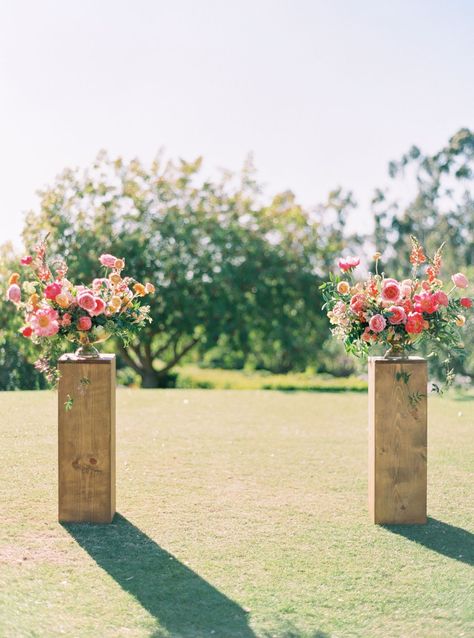 Ceremony vow area floral arrangements on wooden pedestals. Pink large arrangements with coral charm peonies, pink roses, and pink ranunculus, and greenery shot on film by Cavin Elizabeth Photography. Decoration, Wedding, Hochzeit, Bodas, Boda, Mariage, Bloemen, Flores, Deko