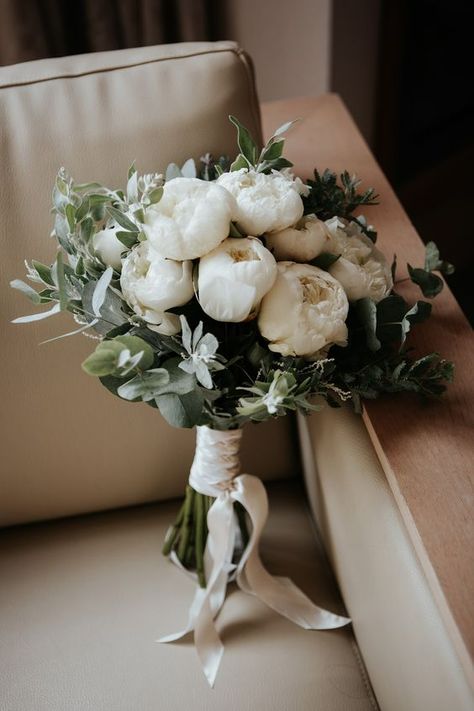 an elegant white peony and greenery wedding bouquet is perfect for a neutral wedding in any season