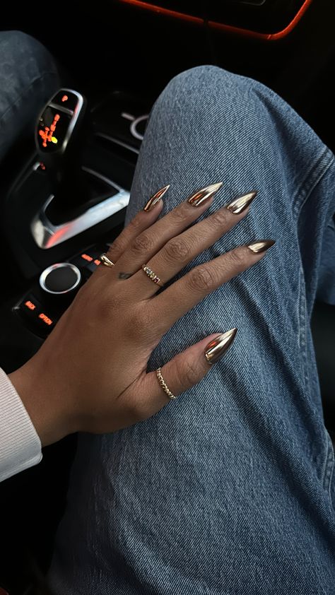 Gold chrome gel-x medium stiletto nails on a black girl’s hand while wearing gold jewelry and rings Gold Chrome Nails, Gold Crome Nails, Gold Stiletto Nails, Black Chrome Nails, Gold Tip Nails, Chrome Nail Polish, Gold Toe Nails, Metallic Gold Nails, Gold Gel Nails