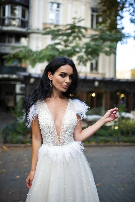 bride wearing a unique modern beaded pearl wedding dress with feathers and a plunging neckline Wedding Dress, Wedding Gowns, Ball Gowns, Wedding Gowns With Sleeves, Beaded Wedding Gowns, Wedding Dress With Feathers, Wedding Dresses With Straps, Wedding Dresses Beaded, Pearl Wedding Dress