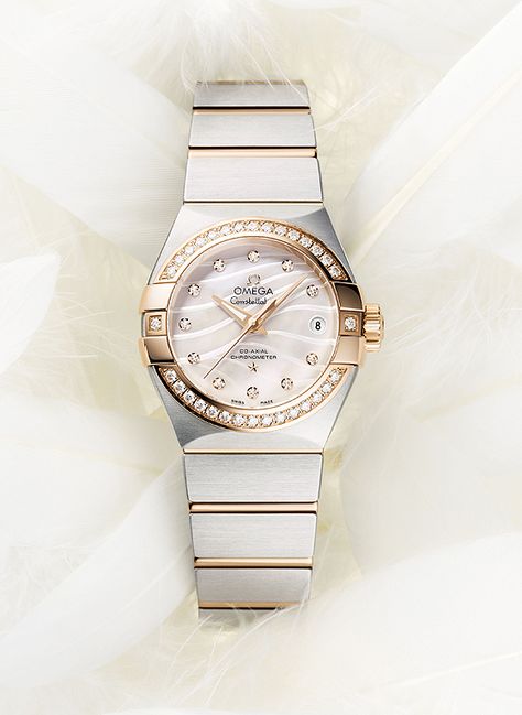 The Omega Constellation Pluma has a mother-of-pearl dial, in natural white or blue, which features an engraved, wavy pattern that recalls the shapes of a feather (“Pluma” is Latin for “feather”). The white-dialed model has a bezel in 18k rose gold and 18k rose gold links in the steel bracelet. Lights, Luxury Watches, Texture, Lighting, Fine Watches, Watch Design, Luxury, Armani Watches, Omega Seamaster