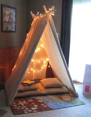 a teepee with lights on it in a bedroom