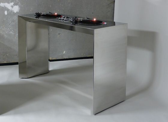 two turntables sitting on top of a metal table in front of a wall