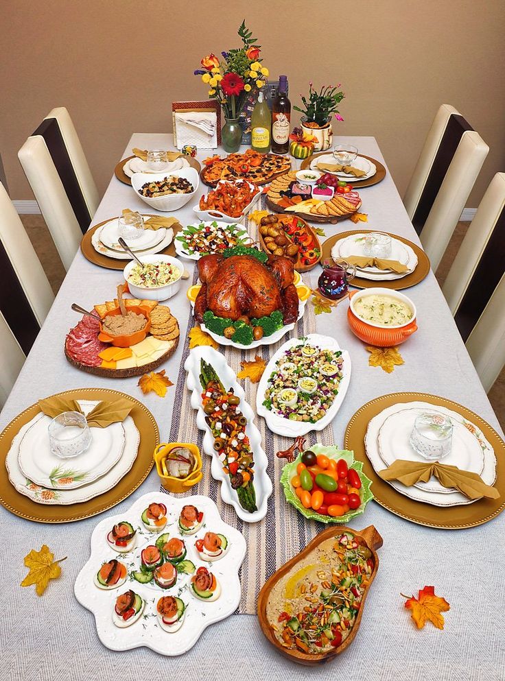a table set for thanksgiving dinner with turkey and other foods