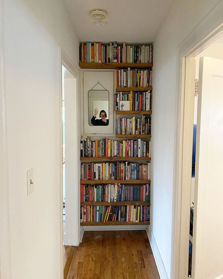 there is a bookshelf full of books in the hallway