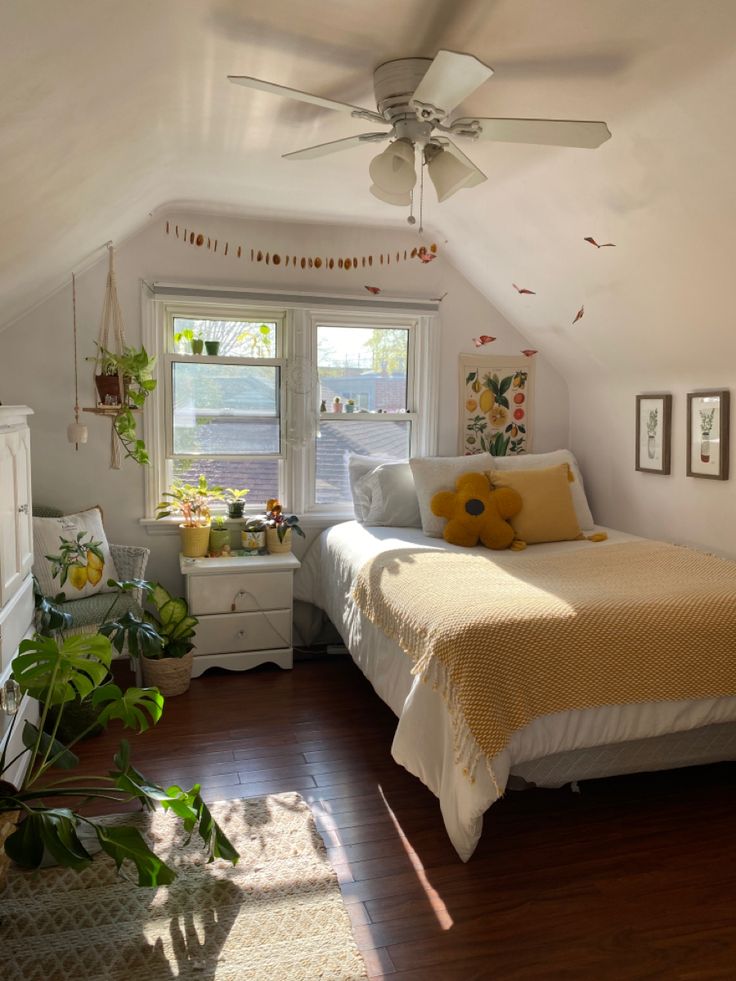 a bedroom with a bed, dresser and ceiling fan in the corner next to a window