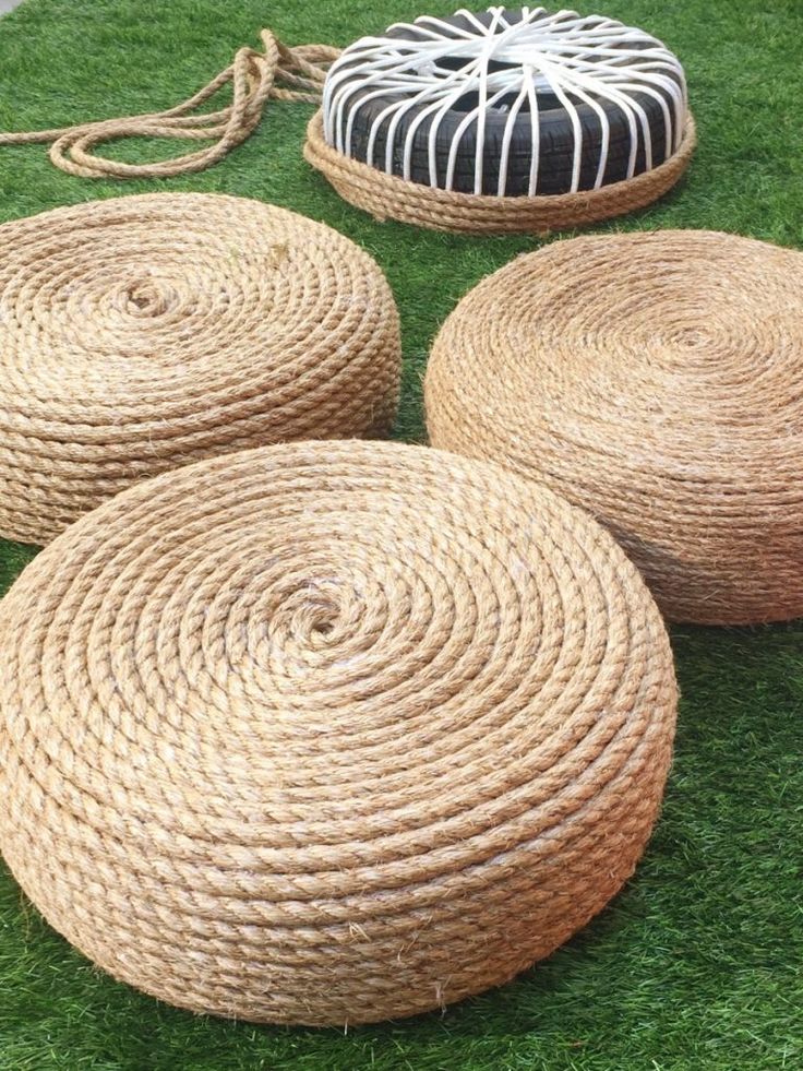 four round baskets sitting on top of green grass next to two black and white pillows