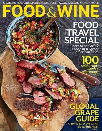 the cover of food and wine magazine, with a wooden cutting board filled with meat