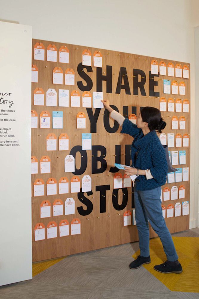 a woman standing in front of a bulletin board that says share yourobi story