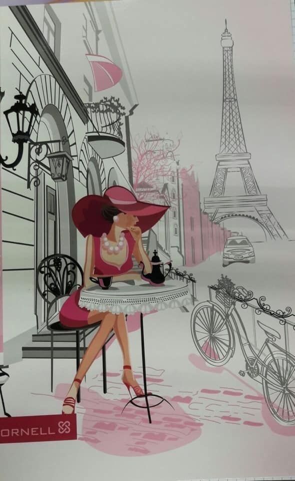 a woman is sitting at a table in front of the eiffel tower with a pink umbrella