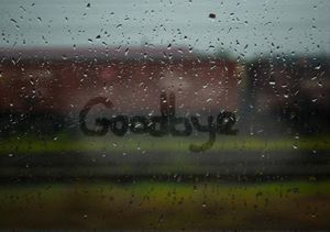 the word goodbye is written on a window with raindrops in front of it
