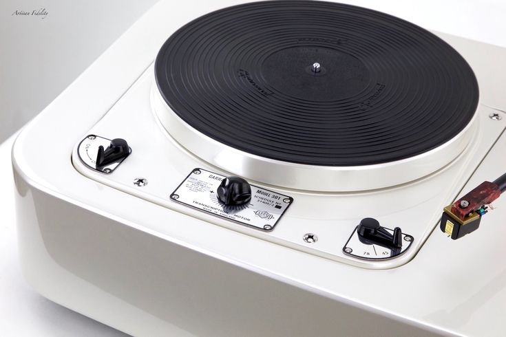 a white turntable with black knobs on it