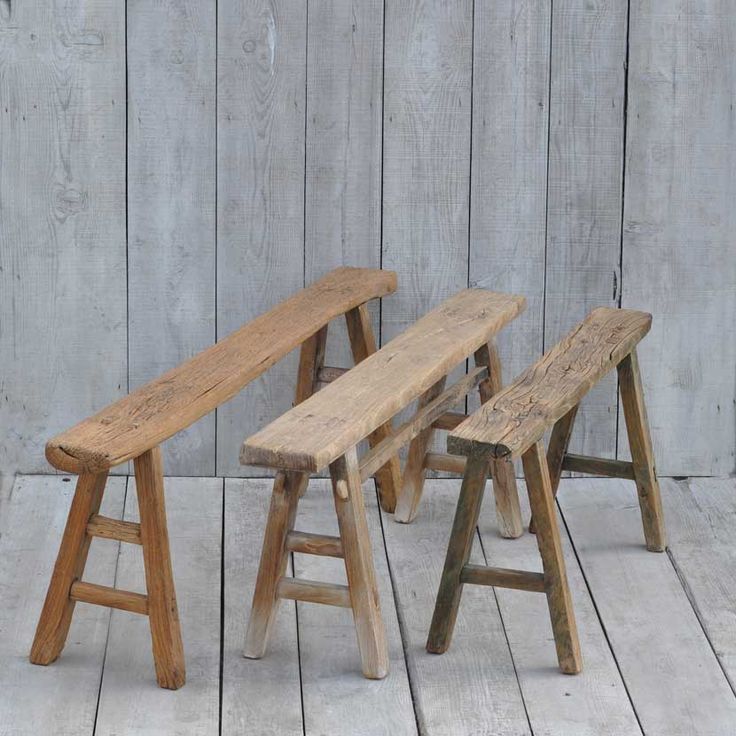 three wooden benches sitting next to each other on top of a whitewashed wood floor