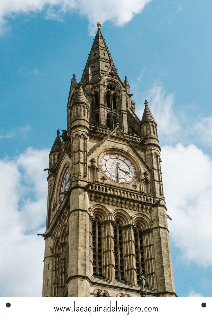 a tall tower with a clock at the top and sky in the backround