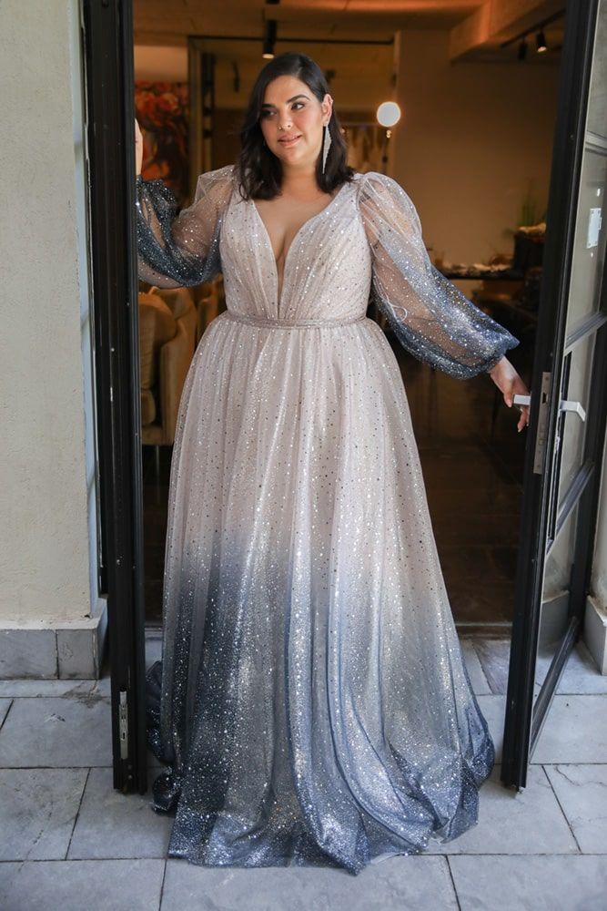 a woman in a long dress is standing at the door with her hands on her hips