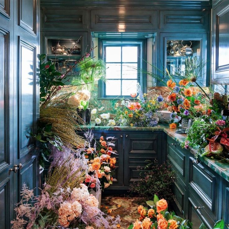 a kitchen filled with lots of flowers and plants