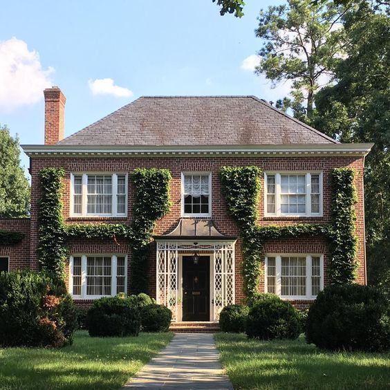 a large brick house with ivy growing all over it