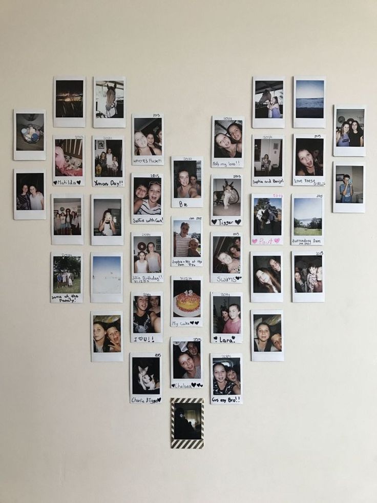 a white wall with many pictures hanging on it's side and one has a heart shaped frame in the middle