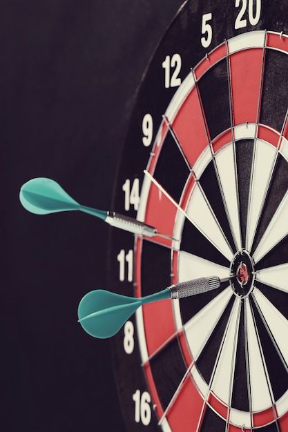 three darts are in the middle of a bullseye dart on a black background with white and red numbers