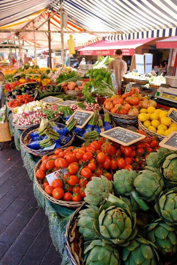 an open air market with lots of fresh fruits and vegetables in baskets on display for sale