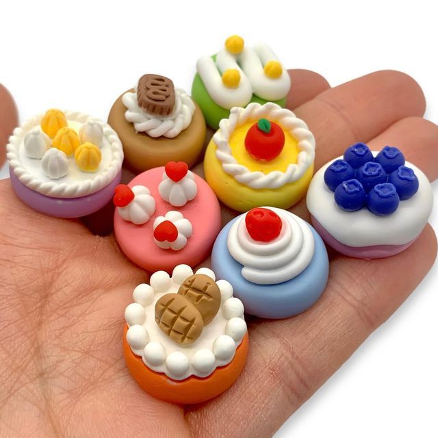 a hand holding a bunch of small toy doughnuts