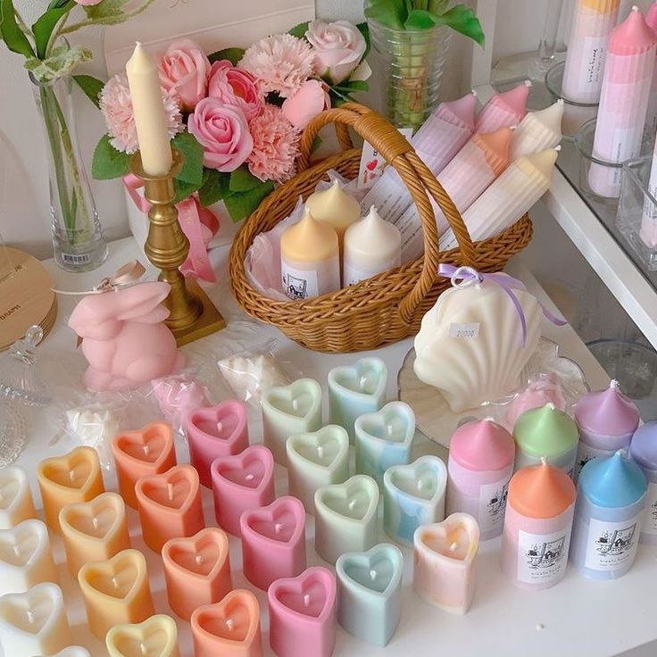 a table topped with lots of different types of soaps and candles next to flowers