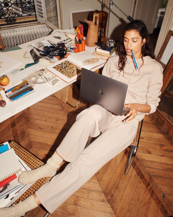 a woman sitting in a chair with a laptop on her lap