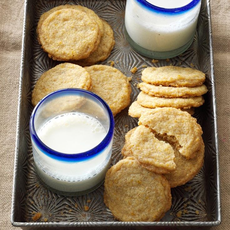 cookies and milk are sitting on a glass plate