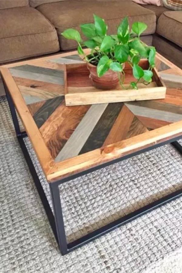 a coffee table made out of wood and metal with a plant in it on top
