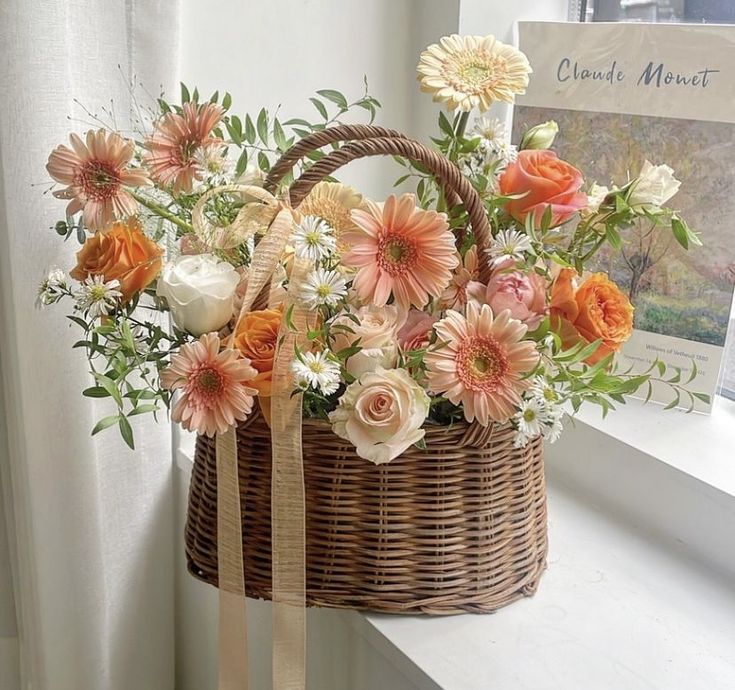 a basket filled with flowers sitting on top of a window sill