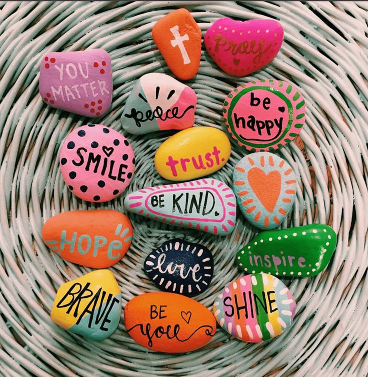painted rocks with words on them sitting in a basket