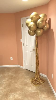 a bunch of balloons that are on top of a pole in the middle of a room