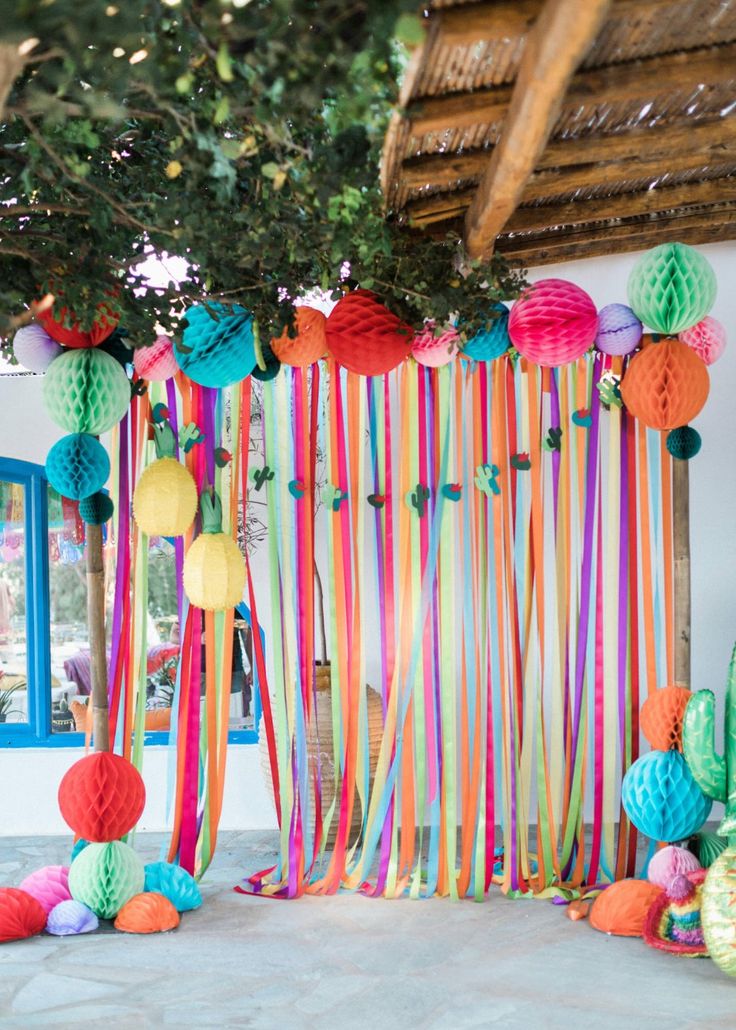 colorful paper balls and streamers are hanging from the ceiling