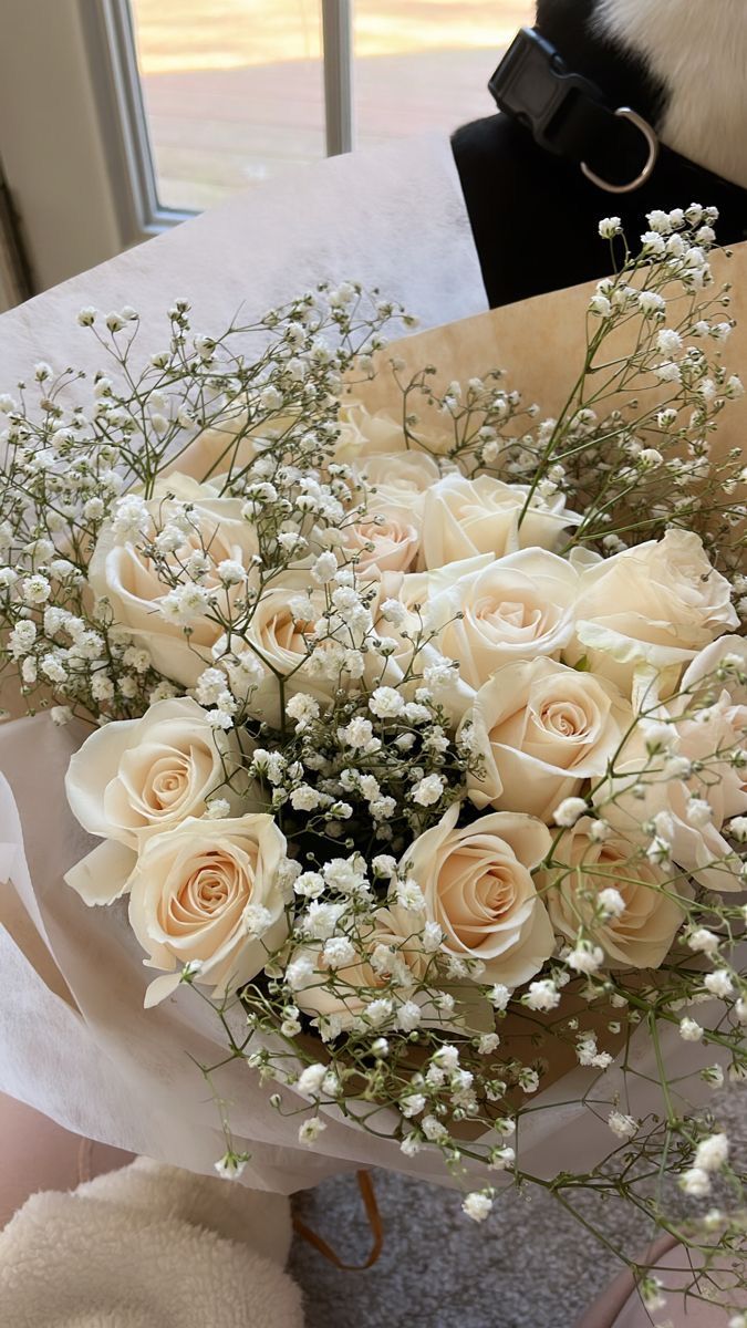 a bouquet of white roses and baby's breath