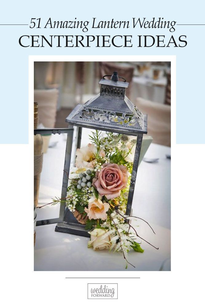 a lantern with flowers and greenery is on the table at a wedding or other function