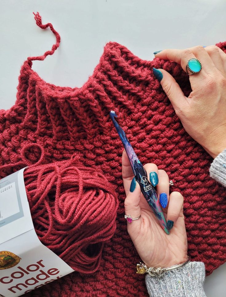 a woman is working on her knitting project