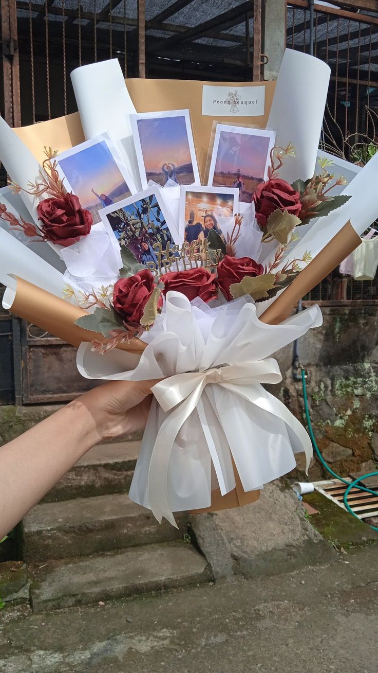 a person holding a bouquet of flowers with pictures on it