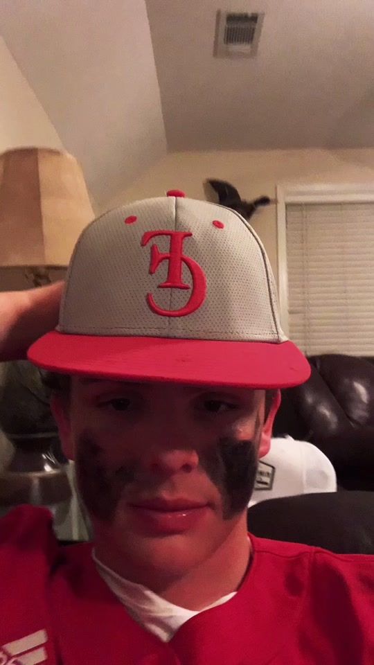 a young man wearing a hat with the letter f on it's peak and red trim
