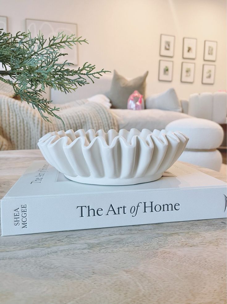 a white vase sitting on top of a book