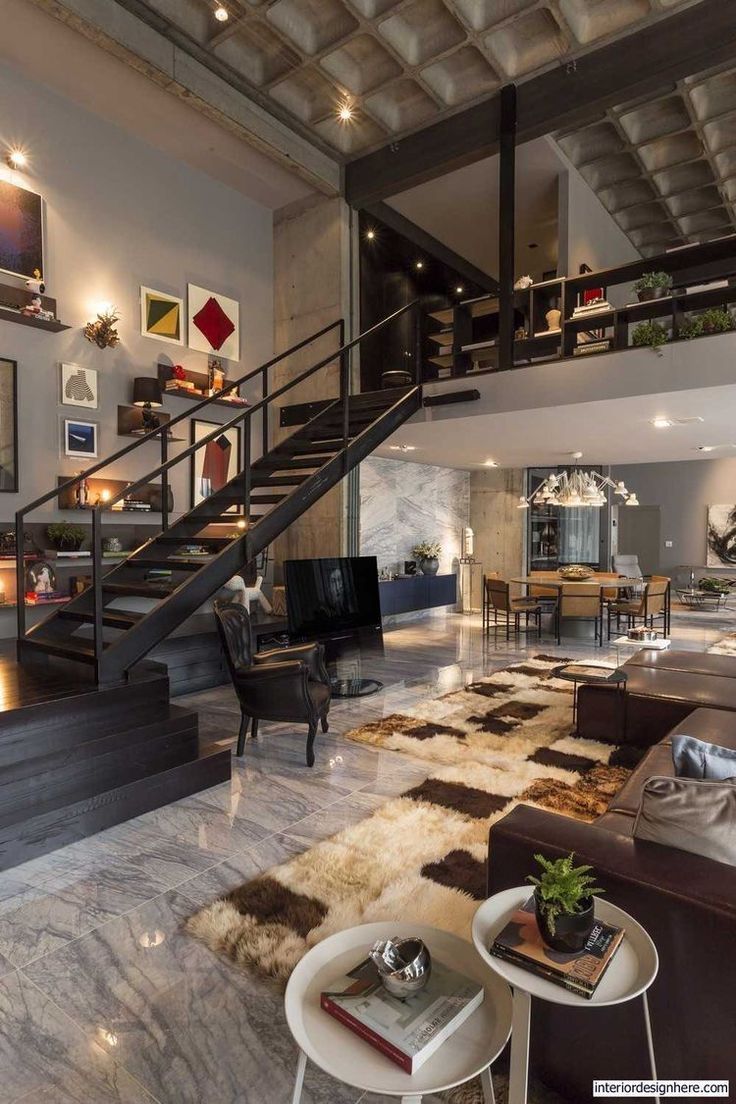 a living room filled with lots of furniture and a staircase leading up to the second floor