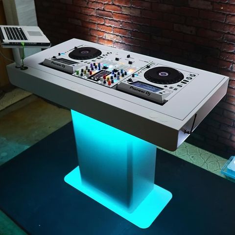 a dj's table with two turntables and a laptop on it