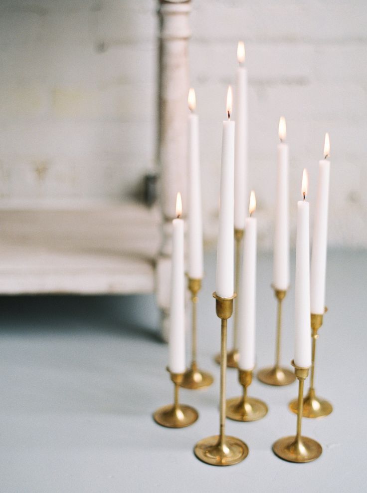 six white candles are lined up in a row