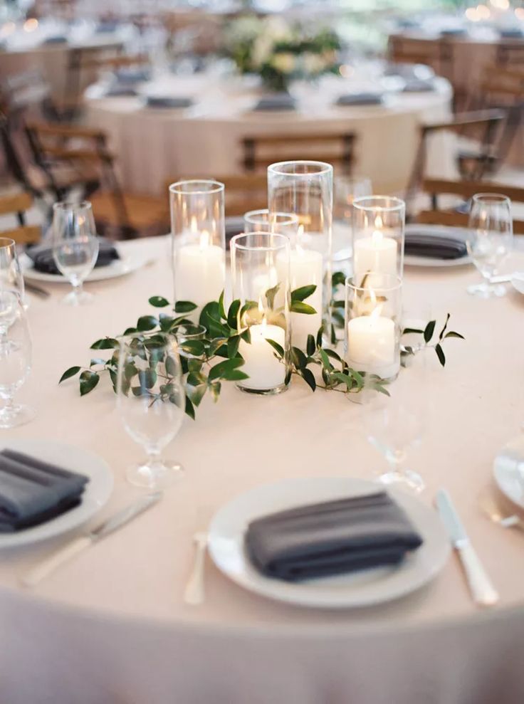 the table is set with candles, plates and napkins for an elegant wedding reception