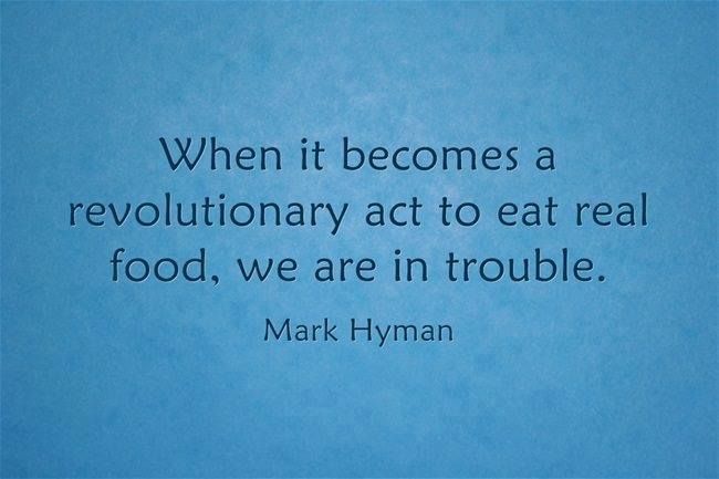mark hyman quote on blue background with black text that reads, when it becomes a revolutionary act to eat real food, we are in trouble