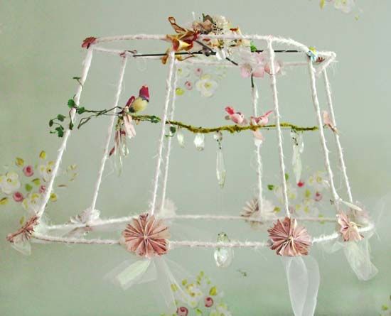 a white birdcage with pink flowers and birds on it