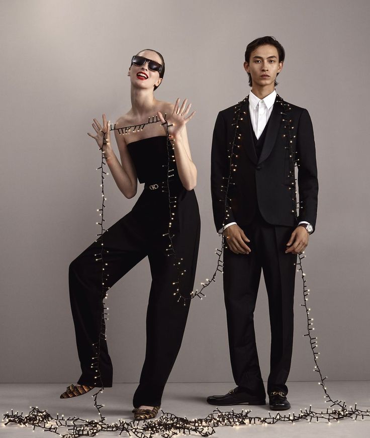 two people dressed in black and white posing for a fashion photo with chains attached to their legs